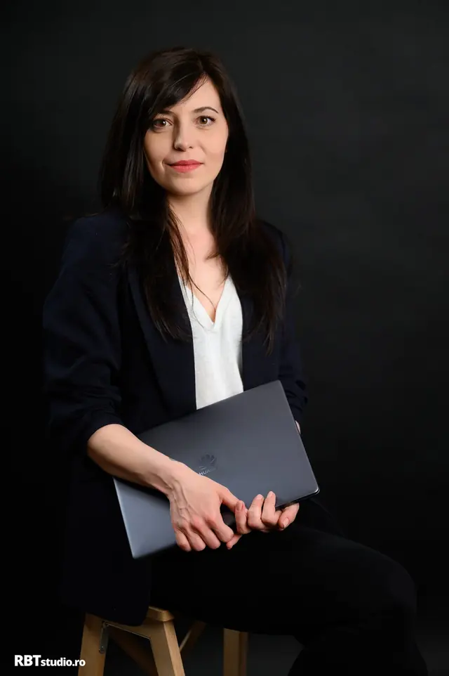 Portret business al unei femei cu laptop, fundal negru
