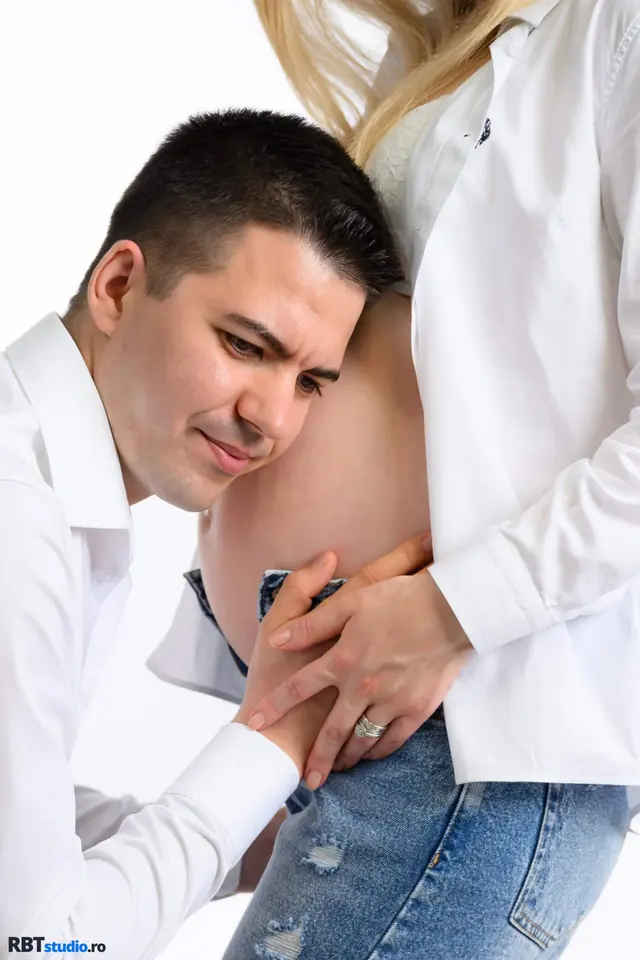 Viitor tată sprijinind burtica partenerei — ședință foto maternity de cuplu