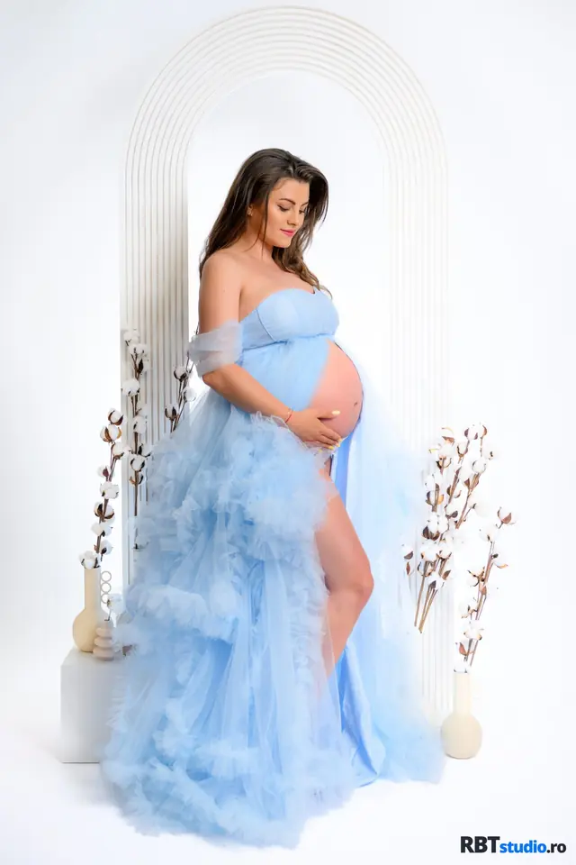 Viitoare mamă în rochie vaporoasă albastră, ședință foto maternity în studio